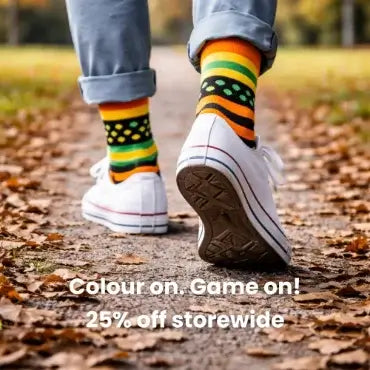 Person wearing colorful socks and white sneakers on a leaf-covered path with promotional text overlay.