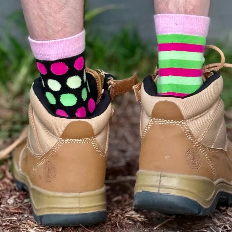 Brown hiking boots with colorful socks on a natural background