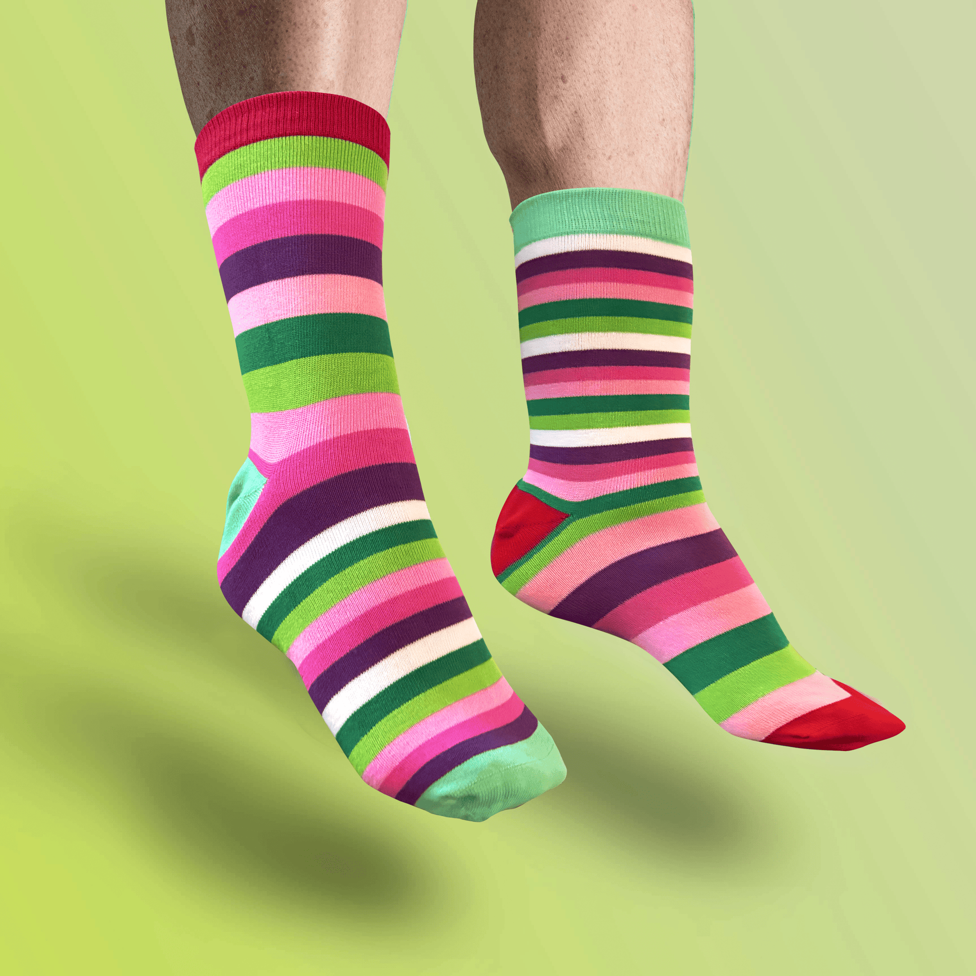 


Colorful striped socks on a person against a green background