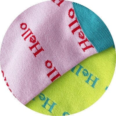 Two fabric swatches, one pink with red text and one green with blue text, on a white background.